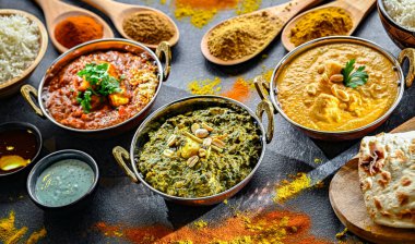 Hint yemekleri ile kompozisyon: medras paneer, palak paneer ve shahi paneer ile orijinal Hint karahi kaplarında servis edilen basmati pilavı