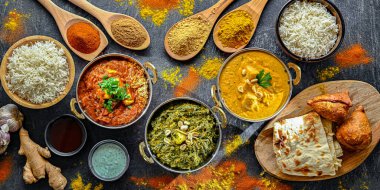 Hint yemekleri ile kompozisyon: medras paneer, palak paneer ve shahi paneer ile orijinal Hint karahi kaplarında servis edilen basmati pilavı