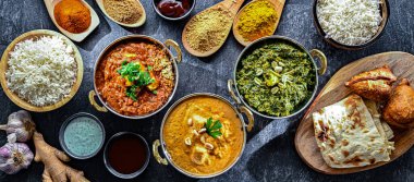 Hint yemekleri ile kompozisyon: medras paneer, palak paneer ve shahi paneer ile orijinal Hint karahi kaplarında servis edilen basmati pilavı