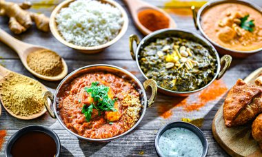 Hint yemekleri ile kompozisyon: medras paneer, palak paneer ve shahi paneer ile orijinal Hint karahi kaplarında servis edilen basmati pilavı