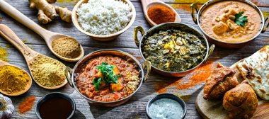 Hint yemekleri ile kompozisyon: medras paneer, palak paneer ve shahi paneer ile orijinal Hint karahi kaplarında servis edilen basmati pilavı