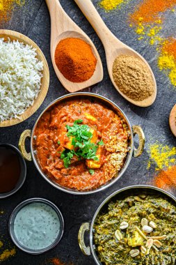 Hint yemekleri ile kompozisyon: medras paneer, palak paneer ve shahi paneer ile orijinal Hint karahi kaplarında servis edilen basmati pilavı