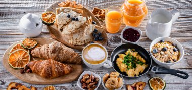 Breakfast served with coffee, orange juice, scrambled eggs, cereals, pancakes and croissants.