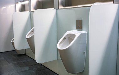 Umumi tuvaletlerde gizlilik duvarları olan sensör kontrollü pisuarlar.