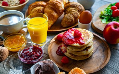 Kahvaltının yanında kahve, portakal suyu, krep, kruvasan, mısır gevreği ve yumurta var..