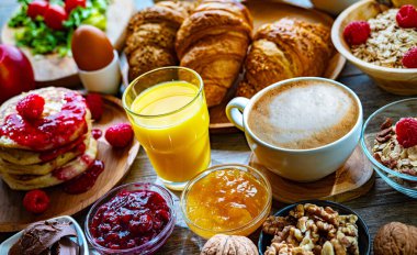 Kahvaltının yanında kahve, portakal suyu, krep, kruvasan, mısır gevreği ve yumurta var..