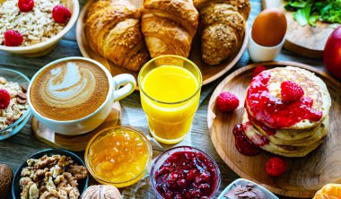 Kahvaltının yanında kahve, portakal suyu, krep, kruvasan, mısır gevreği ve yumurta var..