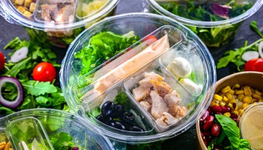 Yuvarlak plastik kutular ve önceden paketlenmiş sebze salataları. Uygun yiyecekler.