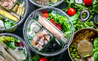 Yuvarlak plastik kutular ve önceden paketlenmiş sebze salataları. Uygun yiyecekler.