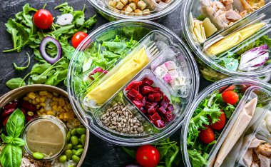 Yuvarlak plastik kutular ve önceden paketlenmiş sebze salataları. Uygun yiyecekler.