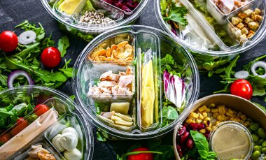 Yuvarlak plastik kutular ve önceden paketlenmiş sebze salataları. Uygun yiyecekler.