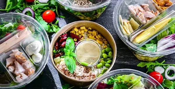 Yuvarlak plastik kutular ve önceden paketlenmiş sebze salataları. Uygun yiyecekler.