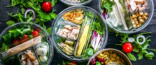 Yuvarlak plastik kutular ve önceden paketlenmiş sebze salataları. Uygun yiyecekler.