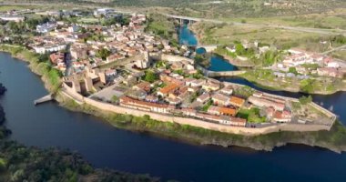 Madrid yakınlarındaki iyi korunmuş tarihi bir köy olan Buitrago del Lozoya 'nın havadan görünüşü, arkasında Guadarrama dağ zinciri ve rezervuar bulunan Lozoya nehri ile çevrilidir. Uzun pozlama.