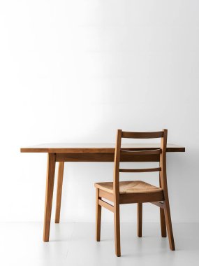 Gündüz vakti aydınlık bir odada minimalist beyaz bir duvara karşı basit bir sandalyeyle modern ahşap masa. Üretici yapay zeka