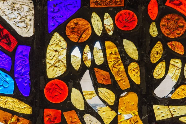 Düzensiz blok desenli renkli bir cam pencerenin resmi.