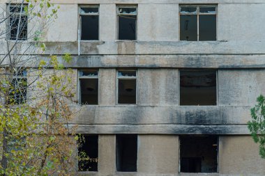 Abandoned building wall with broken windows.