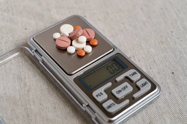 Various pills are on the scales.