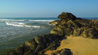 Large stones on the sandy beach at the sea.