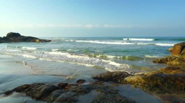 Low waves on a rocky coast of the ocean.