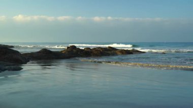 Low waves on rocky coast of the ocean.
