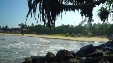 View of the beach with low waves of ocean of Sri Lanka.