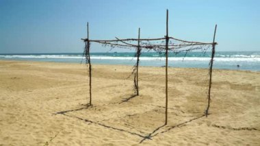 Collapsed awning of bamboo on the beach.