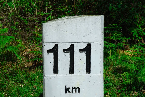 Road concrete marker with a distance 111 km.