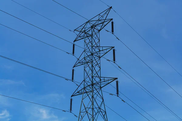 High voltage power lines against a blue sky.
