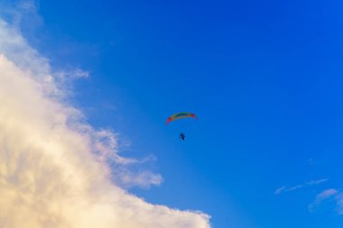 Mavi gökyüzünde ve büyük bulutta paraglider.