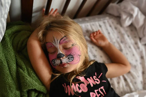Letnia Dziewczynka Pomalowaną Twarzą Dziecko Śpi Swoim Łóżku Zdjęcia Stockowe bez tantiem