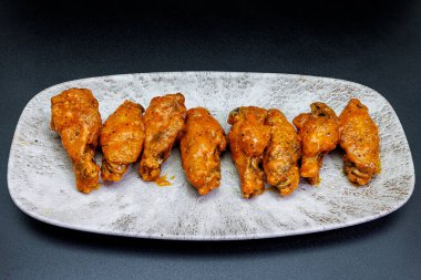 Siyah arka planda Bufalo soslu tavuk kanadı kompozisyonu.