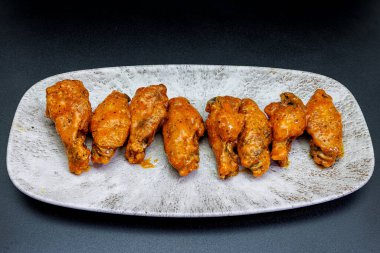 Siyah arka planda Bufalo soslu tavuk kanadı kompozisyonu.