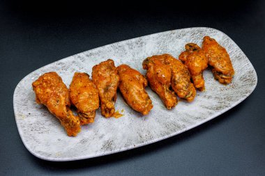 Siyah arka planda Bufalo soslu tavuk kanadı kompozisyonu.