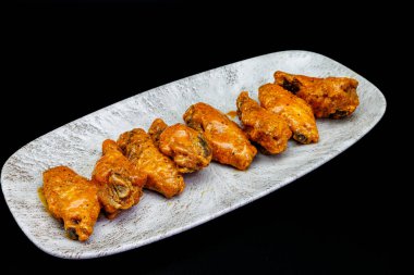 Siyah arka planda Bufalo soslu tavuk kanadı kompozisyonu.