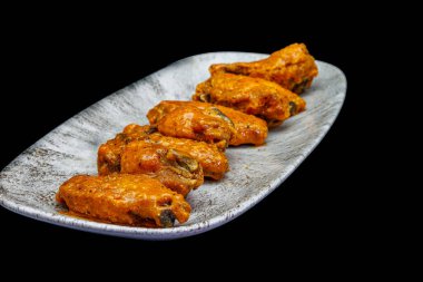 Siyah arka planda Bufalo soslu tavuk kanadı kompozisyonu.