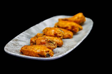 Siyah arka planda Bufalo soslu tavuk kanadı kompozisyonu.