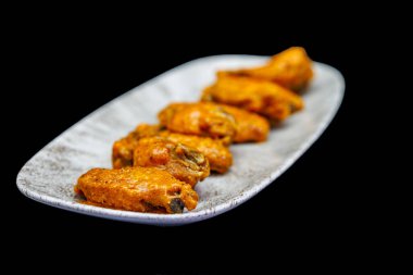 Siyah arka planda Bufalo soslu tavuk kanadı kompozisyonu.