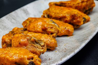 Siyah arka planda Bufalo soslu tavuk kanadı kompozisyonu.