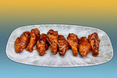 Sarı ve açık mavi gradyan arkaplanda barbekü soslu tavuk kanadı kompozisyonu