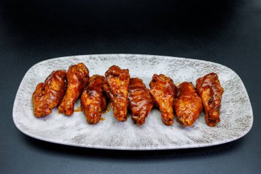 Siyah arka planda barbekü soslu tavuk kanadı kompozisyonu