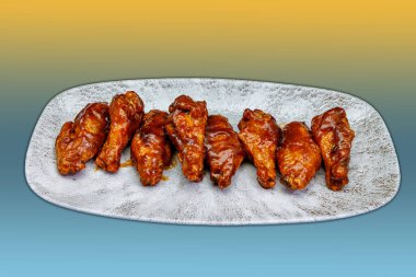 Sarı ve açık mavi gradyan arkaplanda barbekü soslu tavuk kanadı kompozisyonu