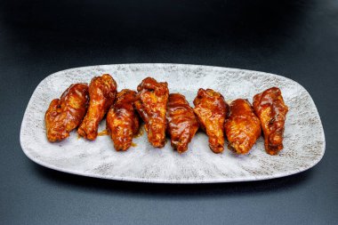 Siyah arka planda barbekü soslu tavuk kanadı kompozisyonu