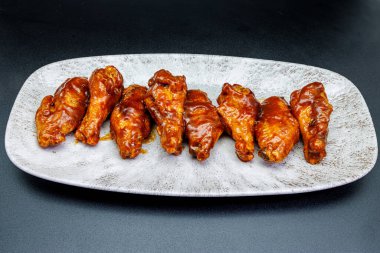 Siyah arka planda barbekü soslu tavuk kanadı kompozisyonu