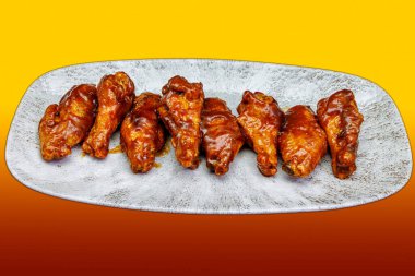 Sarı ve kırmızı gradyan arka planda barbekü soslu tavuk kanadı kompozisyonu