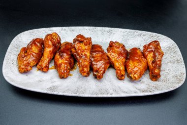 Siyah arka planda barbekü soslu tavuk kanadı kompozisyonu