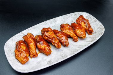 Siyah arka planda barbekü soslu tavuk kanadı kompozisyonu