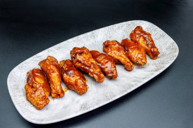 Siyah arka planda barbekü soslu tavuk kanadı kompozisyonu