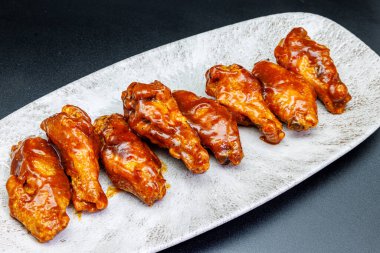 Siyah arka planda barbekü soslu tavuk kanadı kompozisyonu