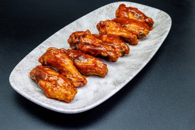Siyah arka planda barbekü soslu tavuk kanadı kompozisyonu
